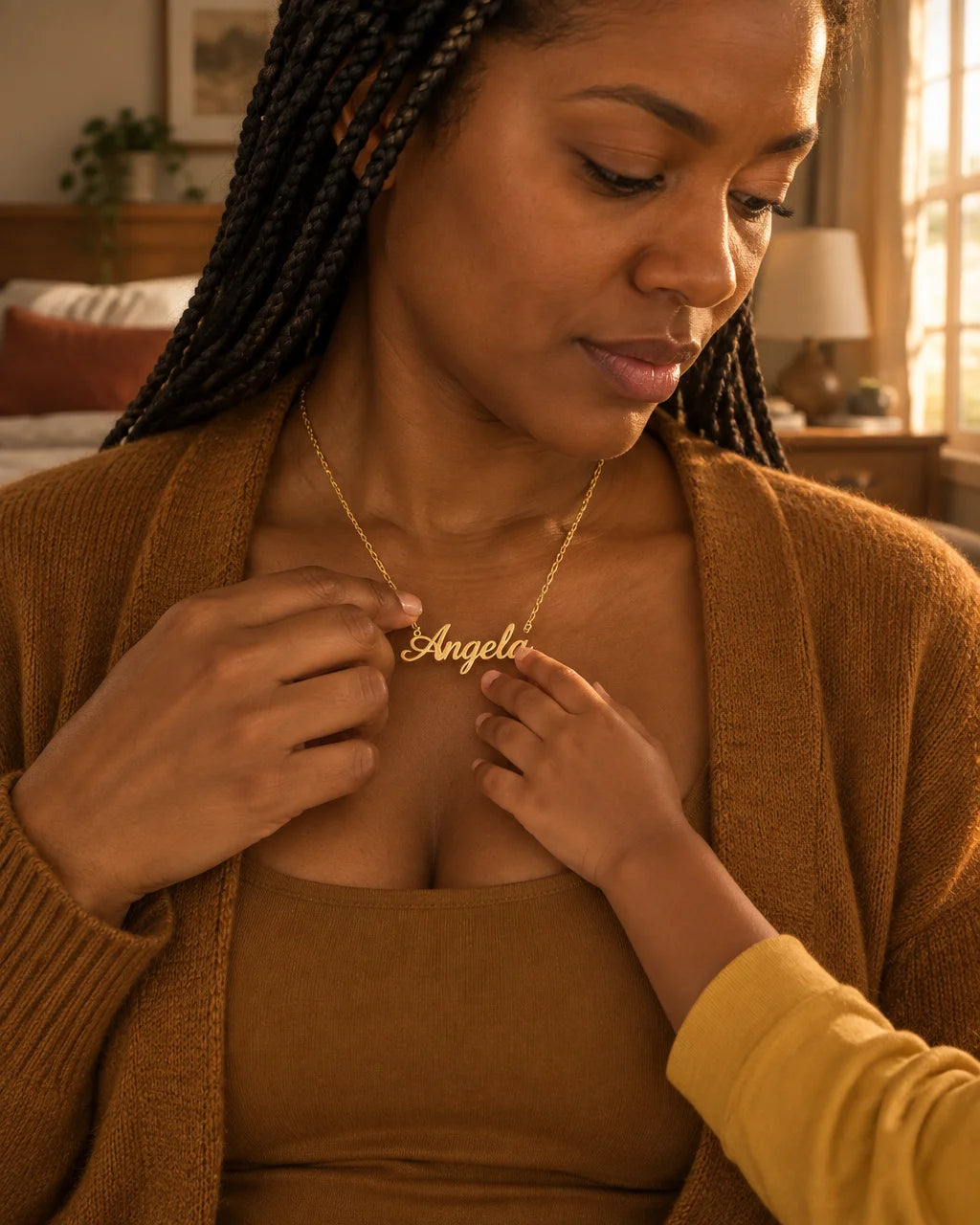 A gold stainless-steel name necklace with a fine chain and cursive pendant, the product large and sh