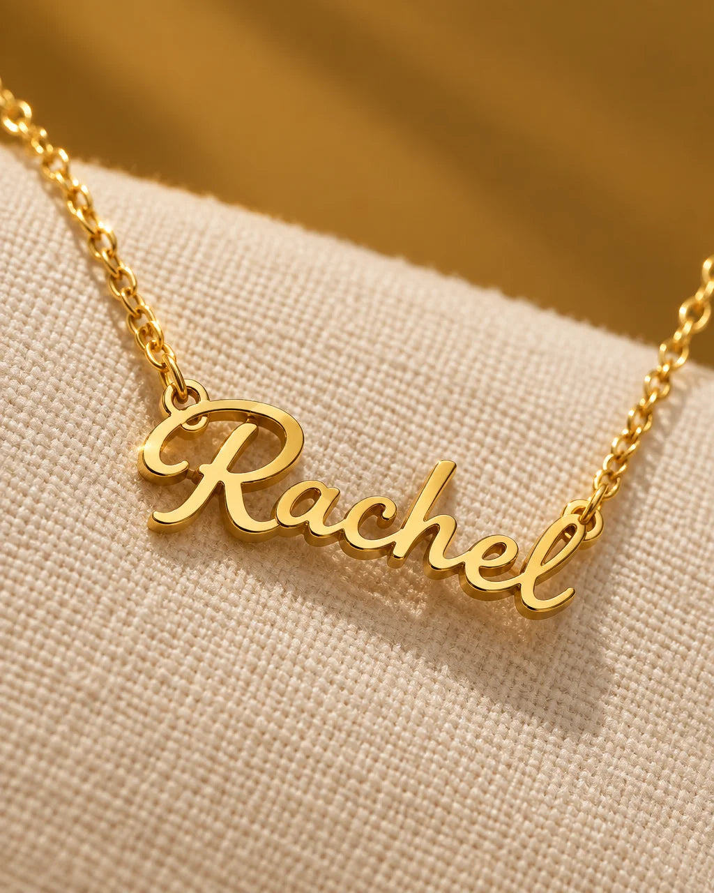 A fine gold stainless-steel chain joined to a continuous cursive name pendant, polished links and de
